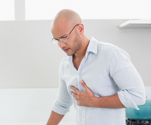 Casual man suffering from chest pain at home